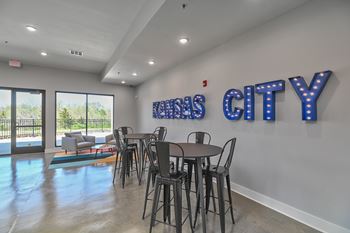 a dining room with a table and chairs in front of a wall with blue letters